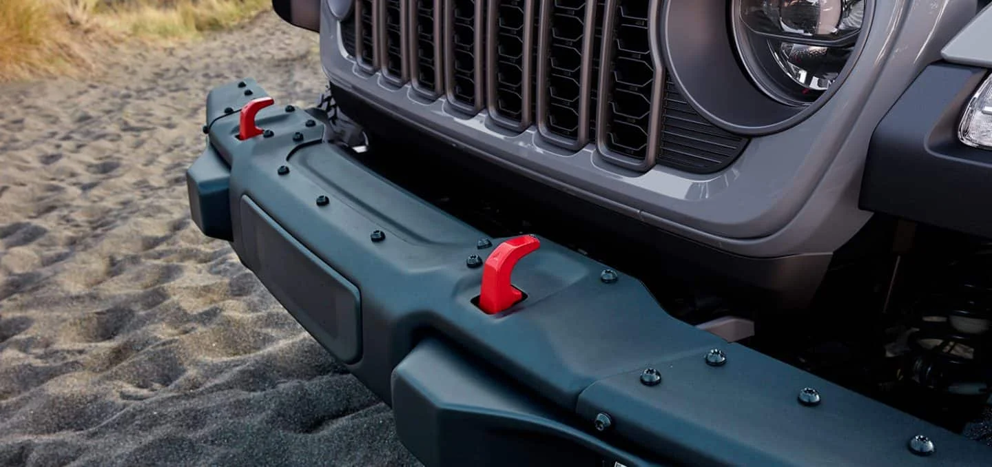 2026 Jeep Gladiator Trail Rated model splashing through water on a rocky off-road trail.